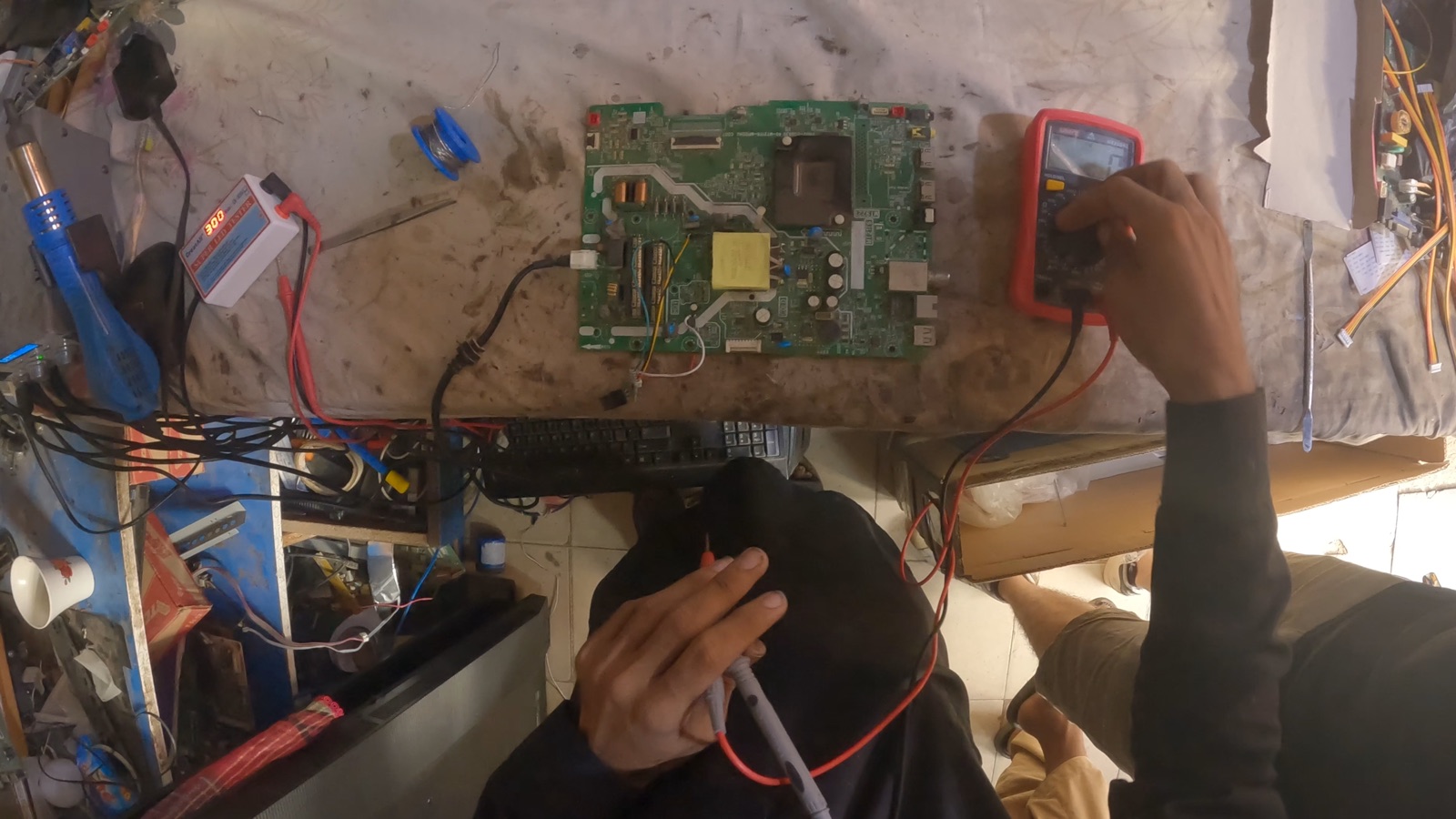 First-person view of a technician testing a circuit board with a multimeter