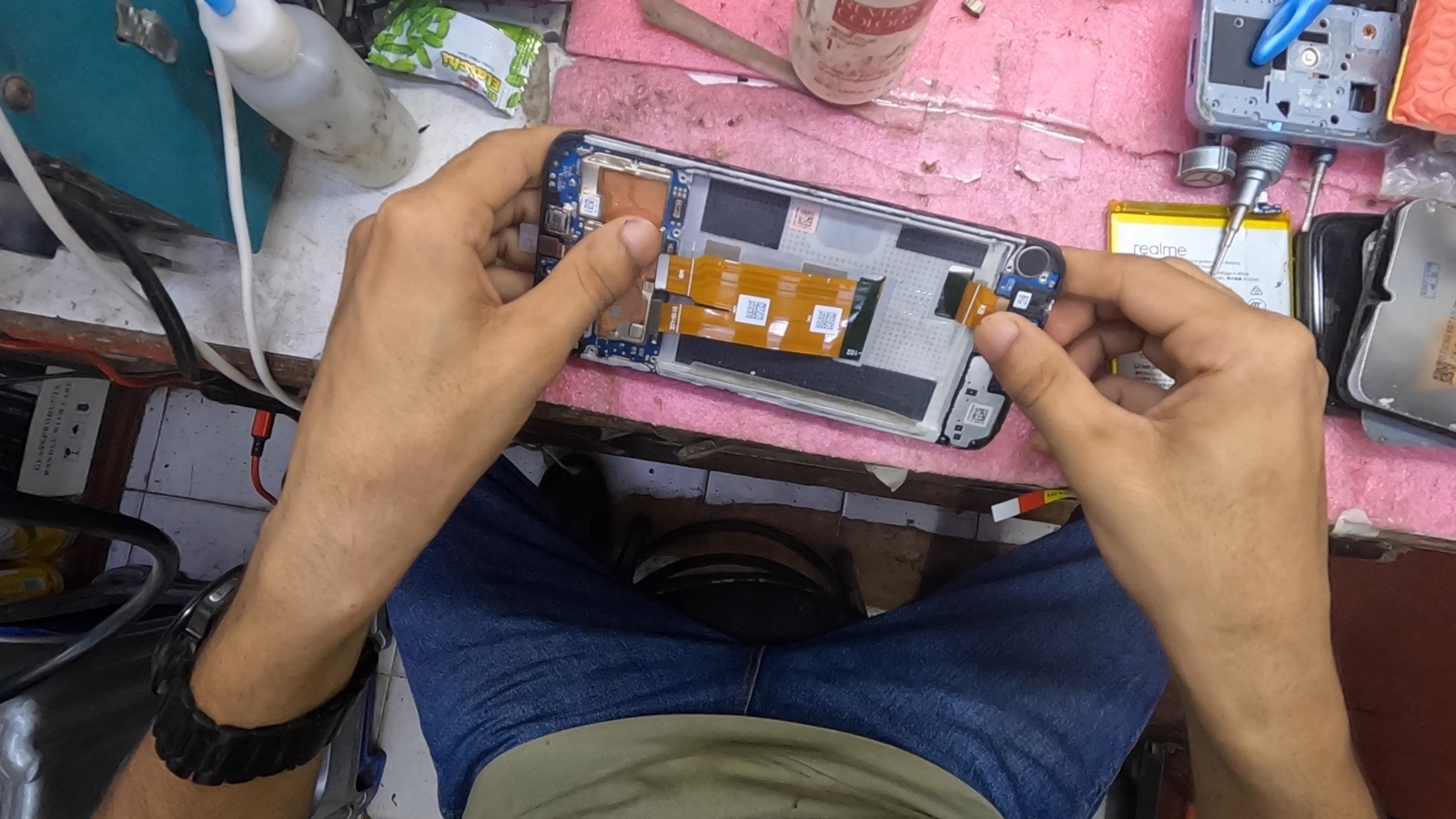 Hands reconnecting a camera module inside a smartphone