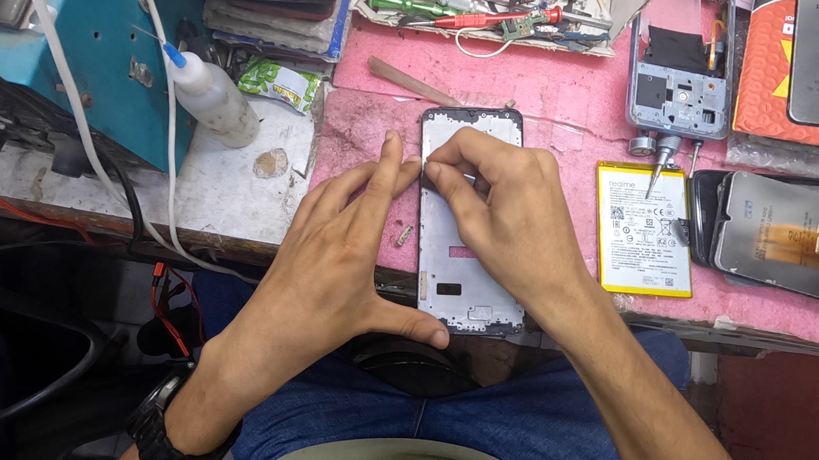 A technician reassembling a smartphone frame